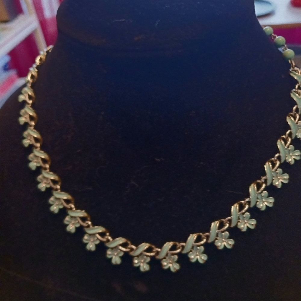 Silver and turquoise colored necklace and bracelet in a floral pattern.